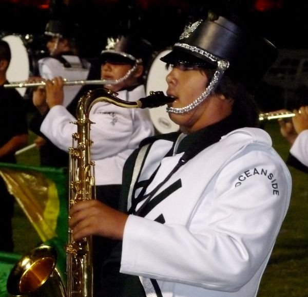 An Oceanside band member plays the saxophone during the halftime performance