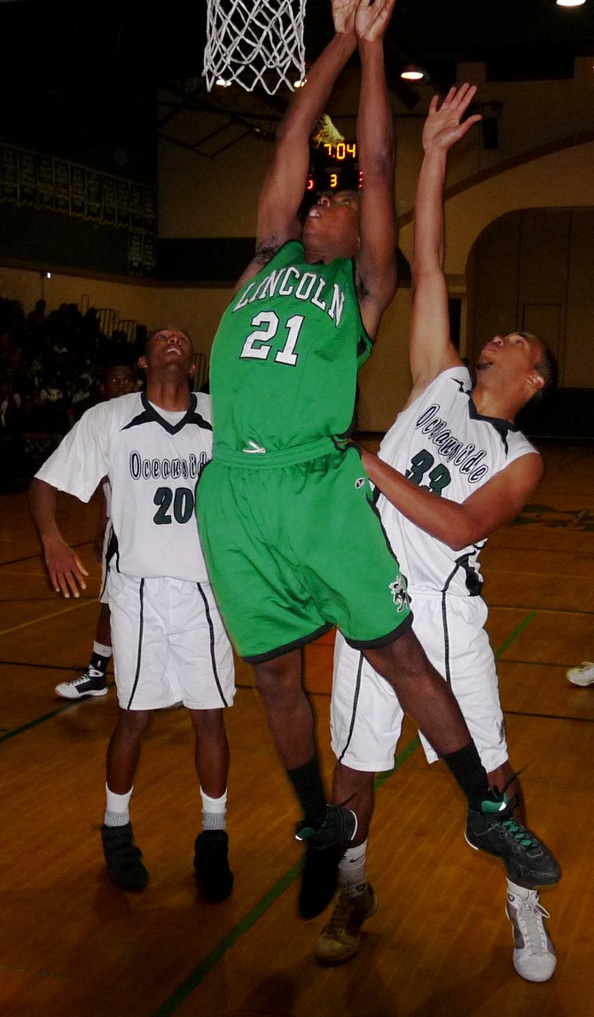 Lincoln forward Javon Barrino goes up for a shot in front of Oceanside forwards Osmond Nicholas and Samuel Mence