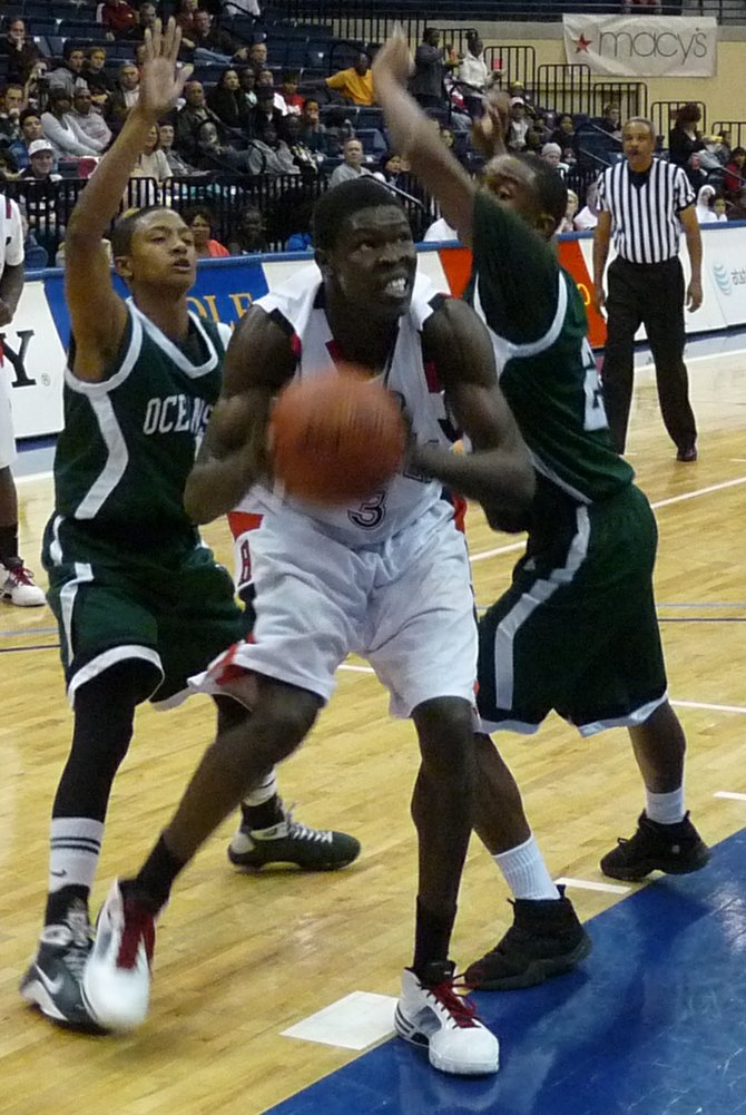 Hoover center Angelo Chol drives through two Oceanside defenders
