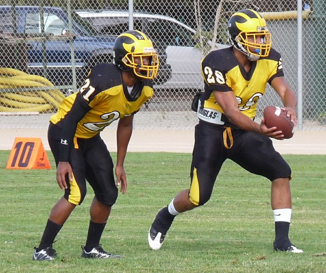 Mission Bay quarterback Dillon Baxter takes the snap with Buccaneers running back Dorian Howard in the backfield