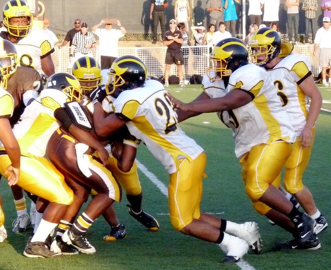 A trio of Mission Bay defenders wrap up Francis Parker quarterback Deon Randall