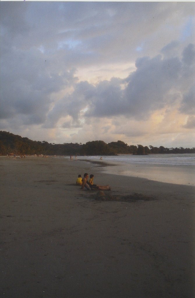A father and two sons pause to enjoy the sunset in Manuel Antonio, Costa Rica. A storm is preparing to move in.
