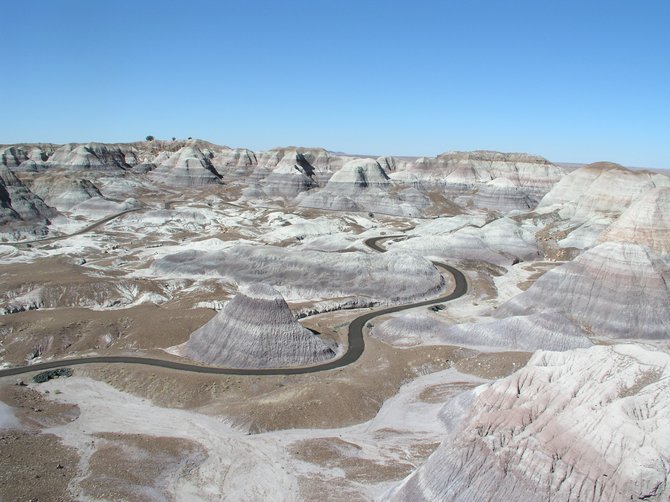 These amazing layers of sculptured sediment and layered mud are known as the Blue Mesas in Petrified Forest National Park, Arizona. Standing in the middle of them on the asphalt trail is truly an "otherworldly" experience.  