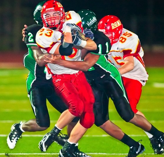 Cathedral Catholic running back Derek Thomas fights for yardage with a pair of Lincoln defenders on his back. 