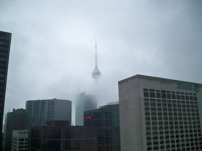 The CN tower peaking through the clouds on a rainy day. 
View from the 38th floor of the Sheraton Center in Downtown Toronto.
