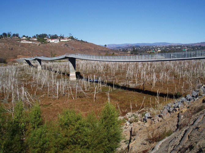 On this day in November 2009, The David Kreitzer Lake Hodges Bicycle Pedestrian Bridge in Escondido spanned a nearly dry lake bed. Today, a month later, the dry brush in the lake bed is sitting in a pool of water.  