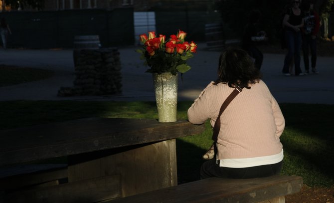 A woman, with flowers, rests in Old Town.