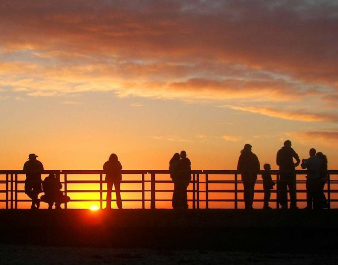 People line up along the breakwater at the Children's Pool in La Jolla to enjoy the sunset.