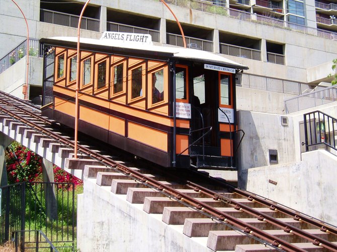  The Angels Flight Railway in Los Angeles is the shortest railway line in the United States. It climbs 298 feet up a steep slope between Hill Street and the Panama Plaza in downtown Los Angeles. It was originally built in 1901 by Colonel J.W. Eddy and is one of the few funicular railways in the United States. A funicular design involves two
counterbalanced train cars attached by a cable on a pulley system, traveling on parallel tracks. The weight of one car moving downward pulls the second car upward along the incline. 