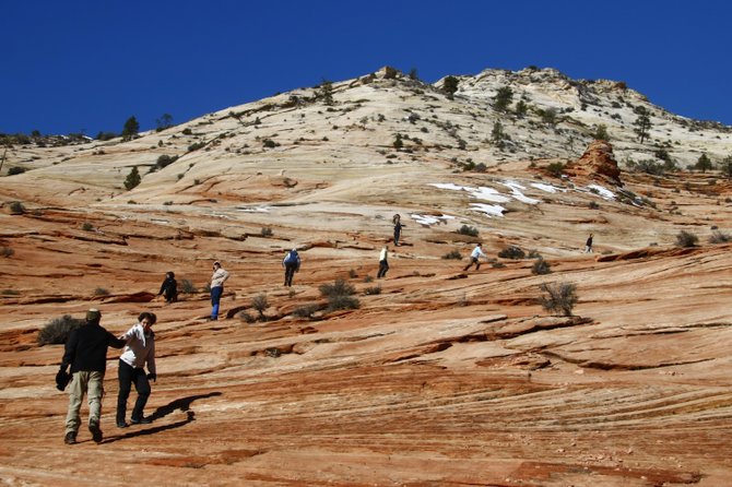 Visitors explore the slickrock in Zion National Park, Utah.