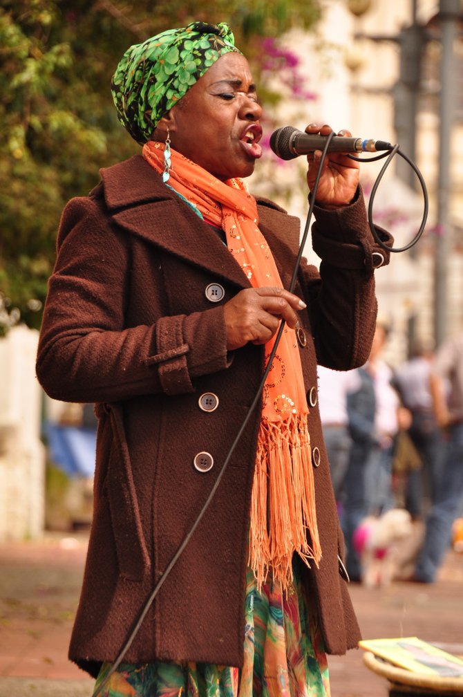 A Caribbean singer interprets songs from Celia Cruz in a busy flea market corner in Bogota, Colombia. The song was "Yerbatero" ("The Weeds Carrier")
