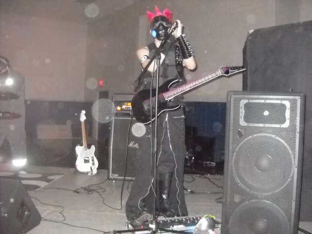 Zombie of Squirrelly Arts band performing (with gas mask) at IB Sports Park.