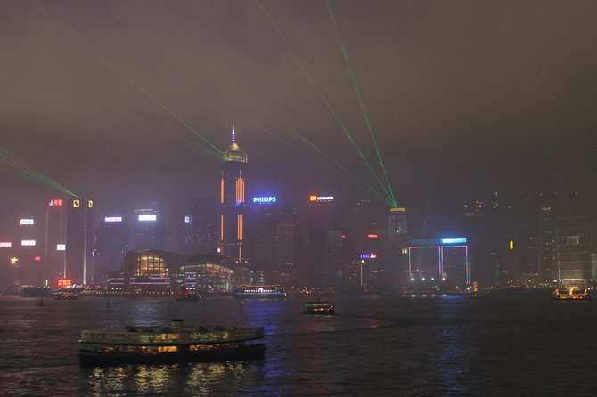 Night light show over Victoria Harbor on a foggy night.

