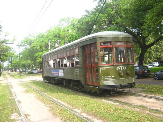 A streetcar rumbles past stately oak trees along St. Charles Avenue in uptown New Orleans.