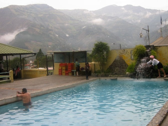 One of the popular La Virgen thermal baths in Baños, Ecuador. The Tungurahua Volcano is in the background.