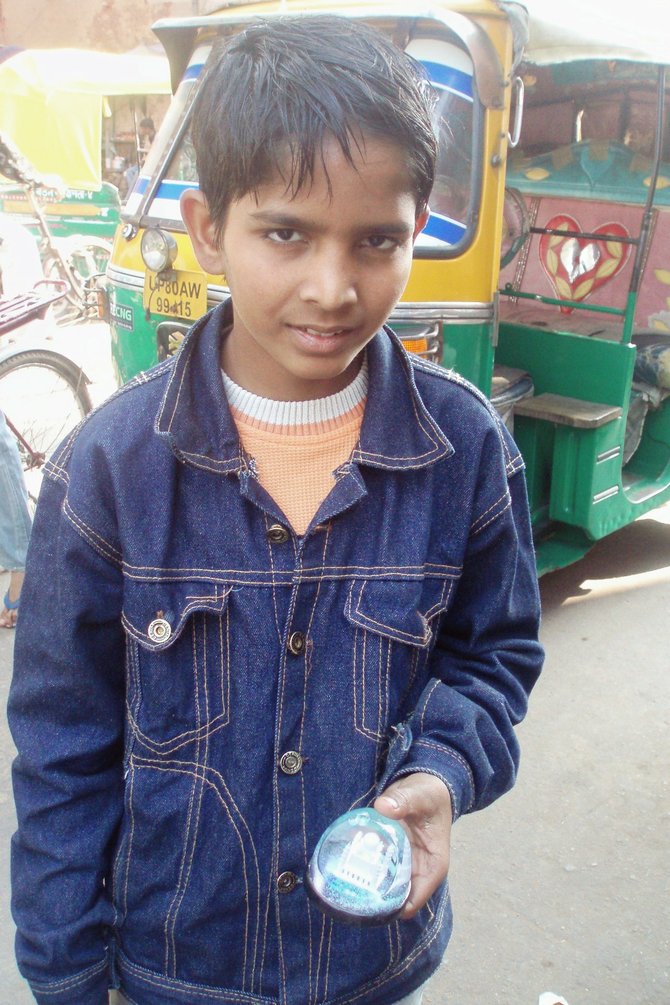 This boy helps support his family by selling mini versions of the Taj Mahal in Agra, India.
