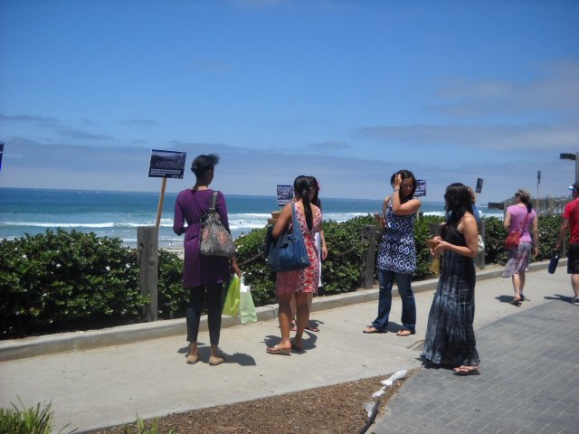 Ladies along boardwalk near Crystal Pier observing Hands Across the Sand.
