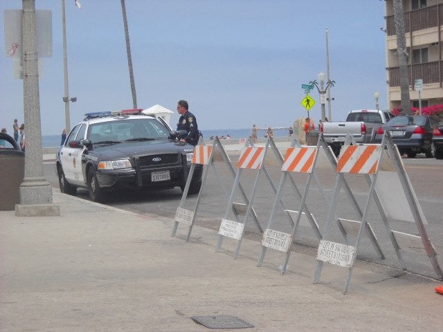 Cops block entrance to full Newport Ave. parking lot on 4th of July.