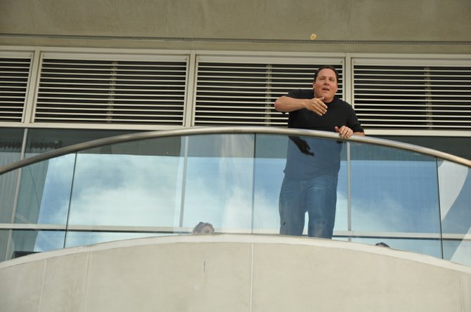 Jon Favreau tosses a coin off the balcony to a fan waiting in line for the Hilton Bayside Indigo room. 