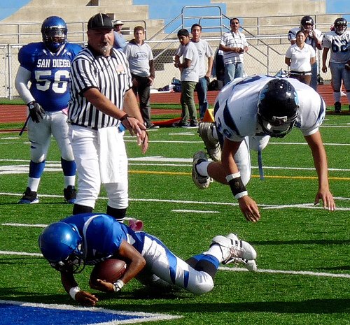 San Diego running back Richard Stroud falls into the endzone underneath a flying tackle attempt by University City linebacker Nico Jacobo