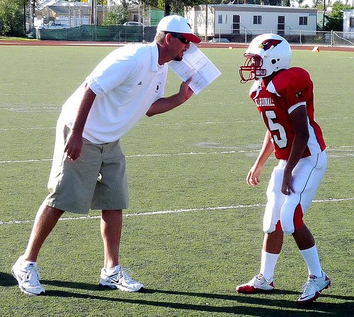 Hoover head coach Cree Morris gives the play to Cardinals quarterback Cheng Moua