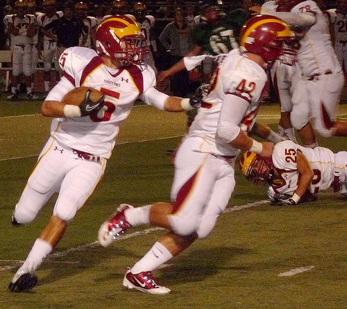 Torrey Pines running back John Wilson carries the ball outside with Falcons teammate Kevin Cuff blocking