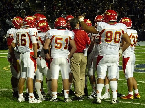 Cathedral Catholic’s offense huddles around head coach Sean Doyle during a timeout