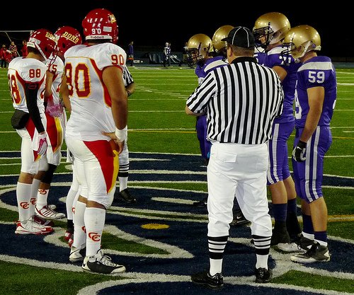 Cathedral Catholic and St. Augustine team captains meet at midfield for the coin toss