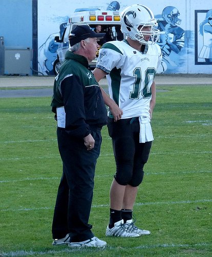 Coronado quarterback Austin Denson (10) and head coach Bud Mayfield talk things over
