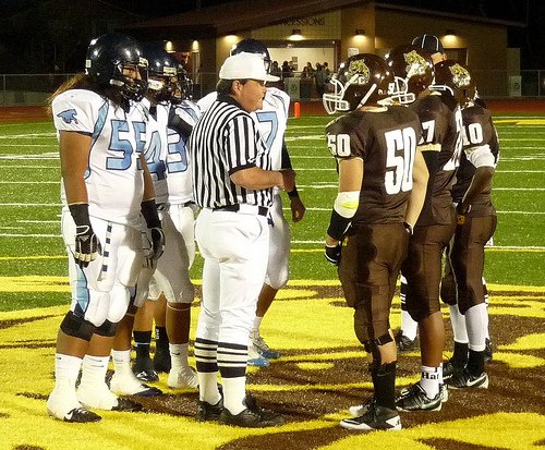 El Camino and Otay Ranch team captains meet at midfield for the coin toss