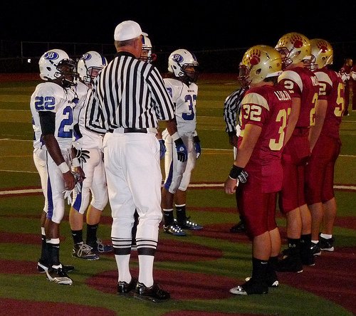 Rancho Bernardo and Mission Hills team captains meet at midfield for the coin toss
