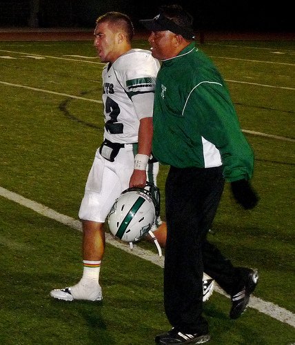 Oceanside running back Noah Tarrant celebrates the Pirates’ semifinal win with an Oceanside assistant coach