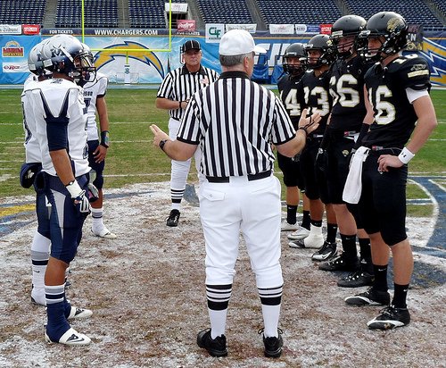 Madison and Valley Center team captains meet at midfield for the coin toss