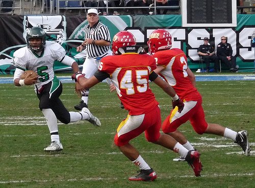 Lincoln quarterback Erick Jones scrambles outside the pocket with Cathedral Catholic linebackers Eric Shlemon (45) and Hugh Yoder (2) in pursuit