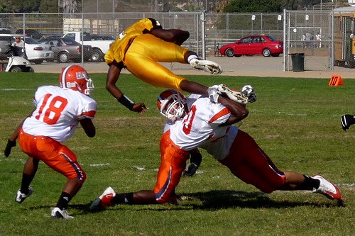 Mission Bay quarterback Nate Long goes airborne between three Valhalla defenders