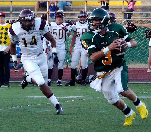 Patrick Henry quarterback James McCormick rolls out with Point Loma defensive end Tevon Heyward hot in pursuit