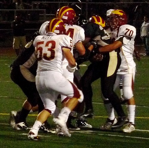 Olympian running back Alex Cornist wrapped up by a pair of Torrey Pines defenders