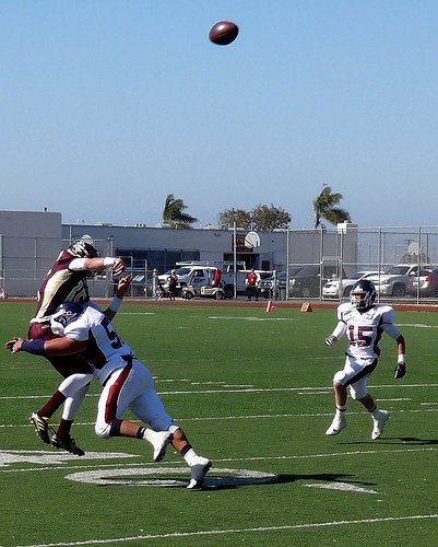 Point Loma quarterback Sean McKaveney lets a pass fly while a Scripps Ranch defender applies a big hit