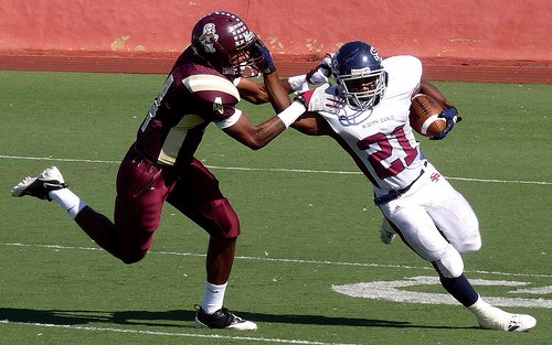 Scripps Ranch running back Austin Dennis applies the stiff arm to Point Loma defensive back Aaron Watkins