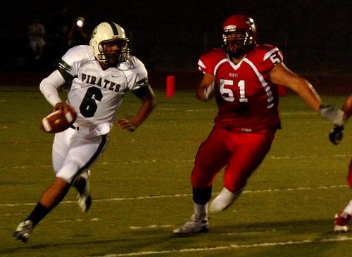 Oceanside quarterback Tofi Pao Pao scrambles outside with Vista defensive lineman Steven Hearn giving chase