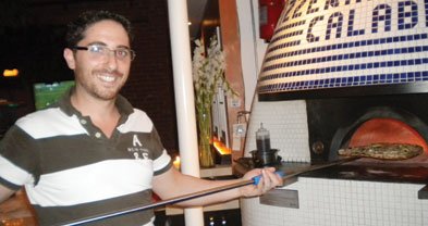 “No gas!” Giancarlo removes a pie from Caffé Calabria’s “pure wood-burning oven.”
