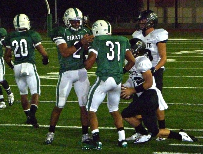 Oceanside defensive end Monte Almaguer (2) and Jermaine Calhoun (31) celebrate a tackle of Servite quarterback Cody Pittman