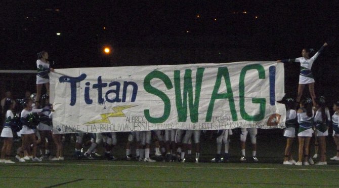Eastlake cheerleaders hold a banner for Titans players to run through after halftime