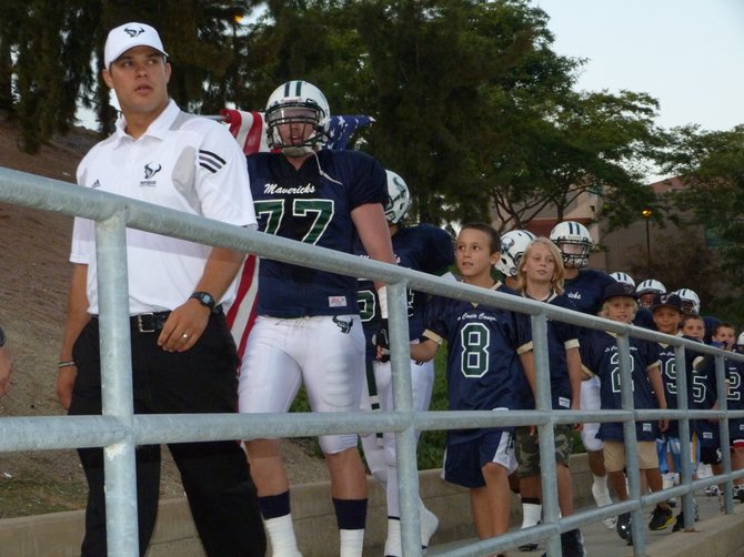 La Costa Canyon head coach Sean Sovacool leads the Mavericks onto the field before their game against Poway