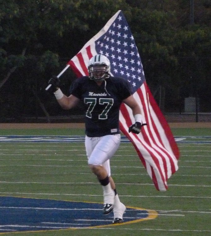 La Costa Canyon lineman Erik Magnuson sprints onto the field with an American flag as a tribute to the 10th anniversary of 9/11
