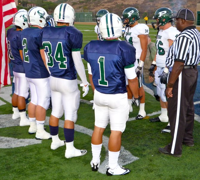 La Costa Canyon and Poway team captains meet at midfield for the coin toss