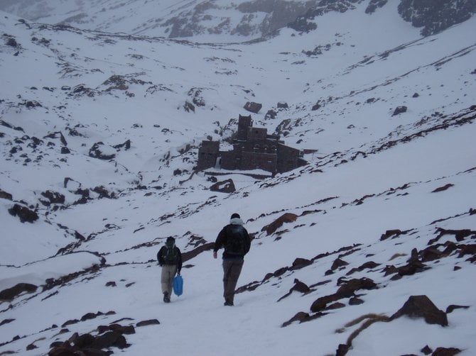 Hiking through the snow with Refuge du Toubkal up ahead