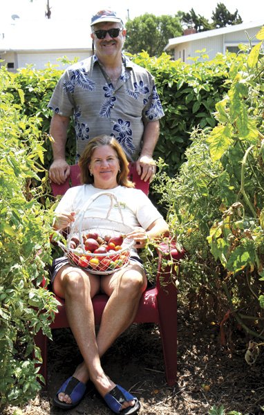 Janet and Kelly Lancaster, surrounded by their 
tomato plants and 20-foot-long passion fruit hedge
