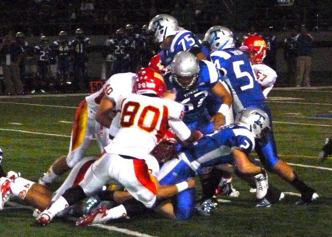 Eastlake running back Jude Isbell stretches for extra yards with two Cathedral Catholic defenders holding on to him
