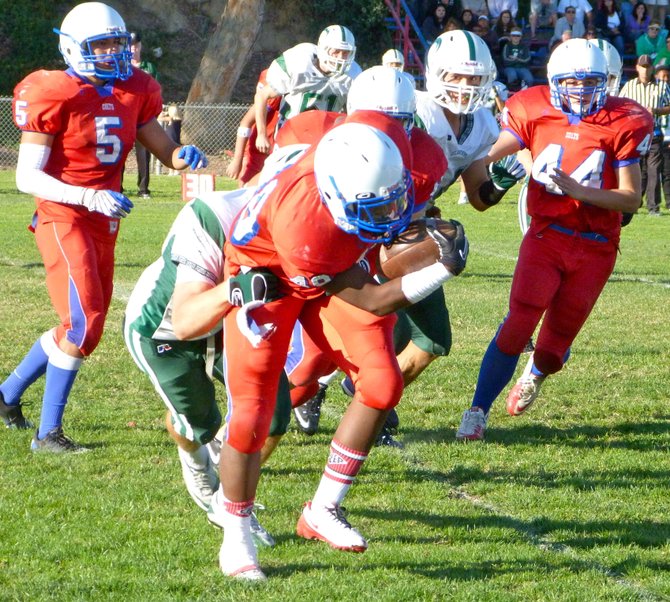 Crawford running back Dominique Lewis fights through the tackle of a Coronado defender